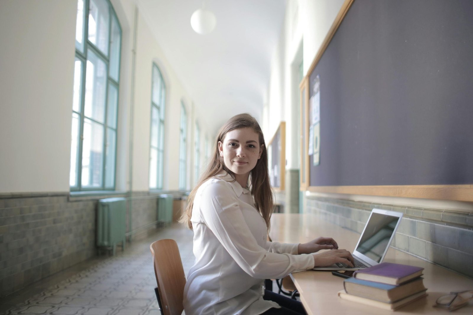 Woman working consistently on a laptop in a quiet study space, representing discipline and daily effort.